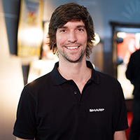 A man in a black t-shirt smiling