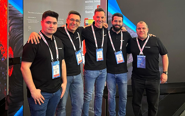 Five gentlemen standing at a trade show exhibition