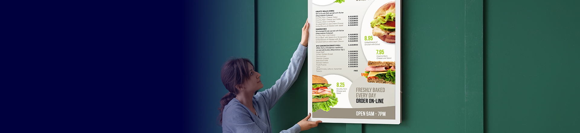 A lady hangs a picture on the wall