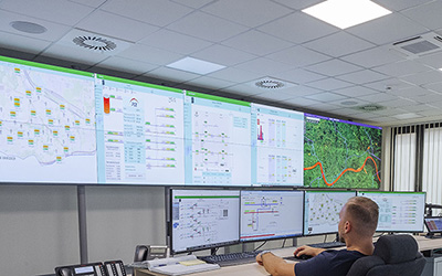 a control room operator sits in front of a bank of screens