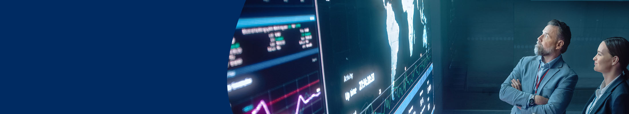 Man and woman view data on a huge LED videowall